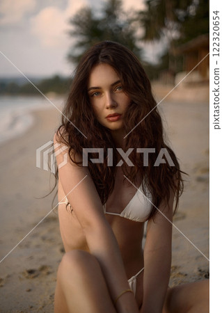 Beautiful model in sand on beach. Sexy girl in Bikini 122320654