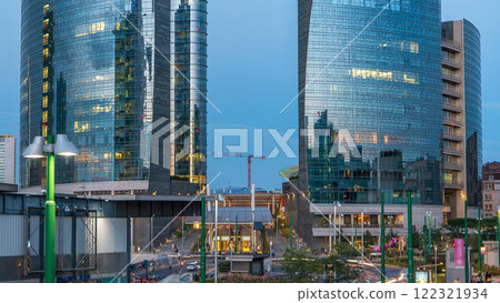 Milan skyline with modern skyscrapers in Porta Nuova business district day to night timelapse in Milan, Italy, after sunset. Milan skyline with modern skyscrapers in Porta Nuova business district day to night timelapse in Milan, Italy, after sunset. 122321934