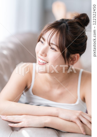 年輕女子躺在沙發上看著窗外 年輕女子躺在沙發上看著窗外 122322450
