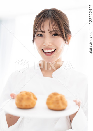 糕點師拿著奶油泡芙微笑 122322465