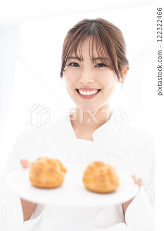 糕點師拿著奶油泡芙微笑 122322466