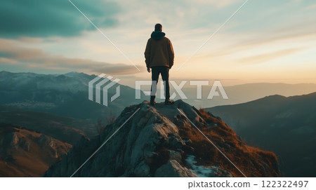 Hiker Standing on a Mountain Ridge Admiring Panoramic View at Sunset 122322497