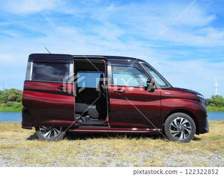 A car with its sliding doors open parked by the river A car with its sliding doors open parked by the river 122322852