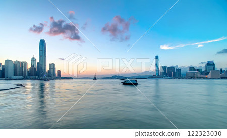Hong Kong, China skyline panorama with skyscrapers at evening from across Victoria Harbor timelapse. 122323030