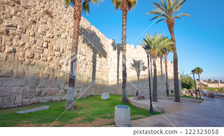 Defensive wall of the ancient holy Jerusalem timelapse hyperlapse, lit by the bright sun. Wonderful green lawn 122323058