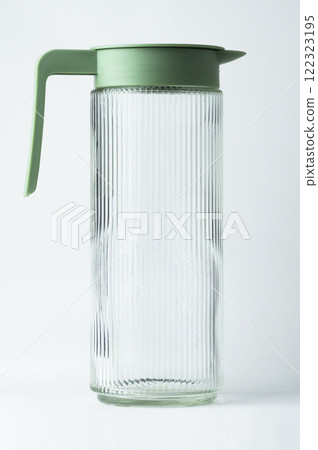 clear glass pitcher features a textured design and a green lid clear glass pitcher features a textured design and a green lid 122323195