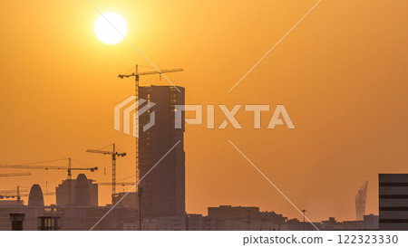 A tower in Doha timelapse, Qatar, under construction, silhouetted against the sunset. 122323330