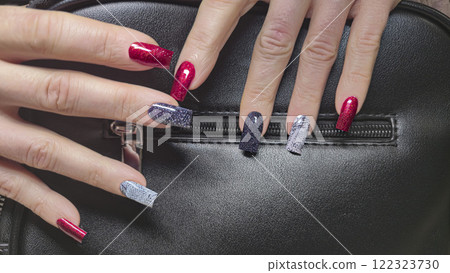 Acrylic nail extensions, manicure and hands in the foreground. Snake skin design 122323730