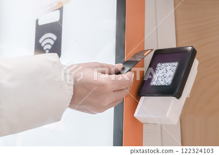 A hand is utilizing advanced contactless payment technology featuring a QR code scanner for convenience, Online payment via QR code through the terminal using a bank credit card, close-up 122324103
