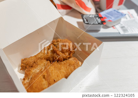 Fried chicken legs are a popular fast food restaurant dish. Unhealthy fried food, Enjoying a delicious takeout box filled with crispy fried chicken, a classic favorite delight Fried chicken legs are a popular fast food restaurant dish. Unhealthy fried food, Enjoying a delicious takeout box filled with crispy fried chicken, a classic favorite delight 122324105
