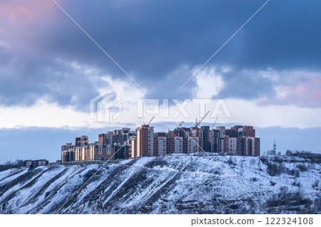 The new residential complex Akademgorodok in Krasnoyarsk, Russia, on a high bank in the winter evening. Contemporary Modern Buildings Resting on a Snowy Hilltop Beneath a Dramatic Sky Above The new residential complex Akademgorodok in Krasnoyarsk, Russia, on a high bank in the winter evening. Contemporary Modern Buildings Resting on a Snowy Hilltop Beneath a Dramatic Sky Above 122324108