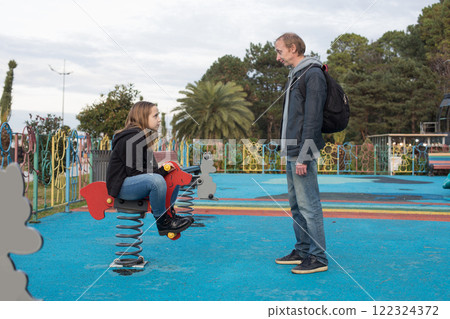 Family on on playground. Smiling father and his child girl outdoors 122324372