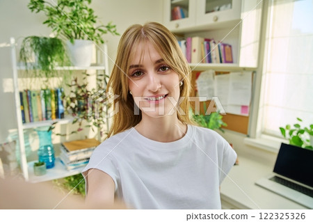 Close-up selfie portrait of teenage female looking at web camera Close-up selfie portrait of teenage female looking at web camera 122325326