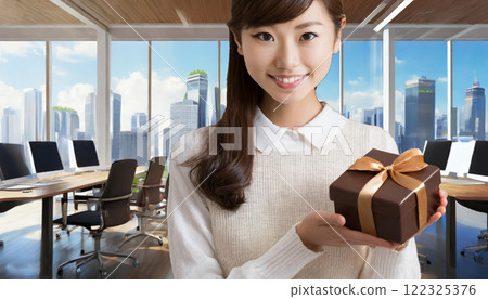 Young woman giving a gift in the office 122325376