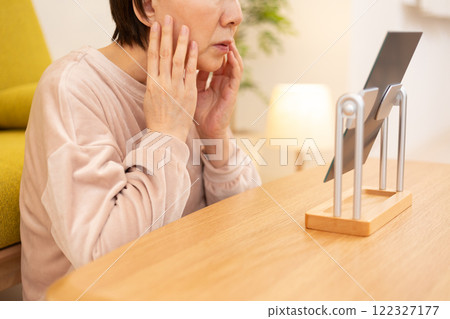 Middle-aged to senior women doing skin care in their room at night Middle-aged to senior women doing skin care in their room at night 122327177
