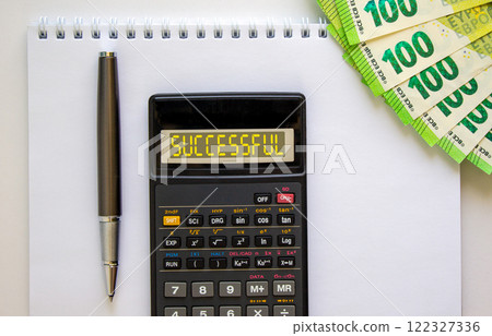 Successful symbol. Concept word Successful on beautiful black calculator. Beautiful white background. Euro bills. Black pen. Business successful concept. Copy space. Successful symbol. Concept word Successful on beautiful black calculator. Beautiful white background. Euro bills. Black pen. Business successful concept. Copy space. 122327336