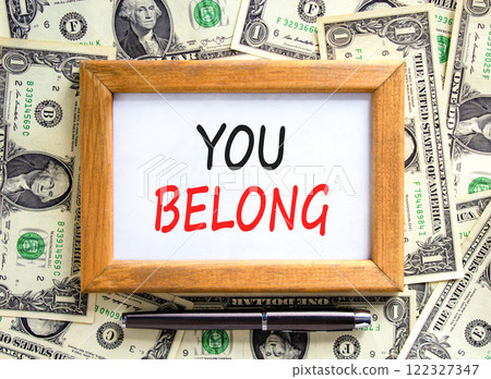Belonging and you belong symbol. Concept words You belong on beautiful wooden picture frame. Beautiful background from dollar bills. Black pen. Business belonging and you belong concept. Copy space. 122327347