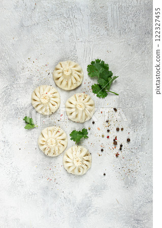 Khinkali, a traditional Georgian dish, with spices and herbs, on the grey table. top view, no people, Khinkali, a traditional Georgian dish, with spices and herbs, on the grey table. top view, no people, 122327455