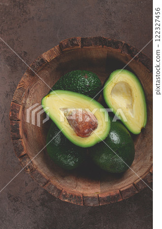 fresh, sliced avocado, in a wooden plate, top view, food background, concept, food styling 122327456