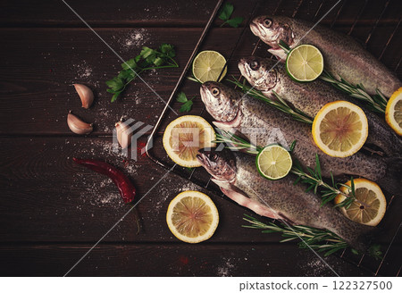 Raw rainbow trout, with lemon and herbs, on a wooden table, no people, Raw rainbow trout, with lemon and herbs, on a wooden table, no people, 122327500