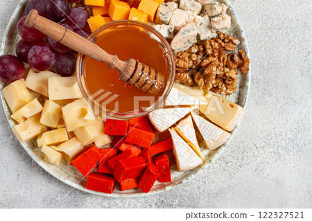 Appetizer, assorted cheese, with nuts and honey, on a round plate, top view, no people, Appetizer, assorted cheese, with nuts and honey, on a round plate, top view, no people, 122327521