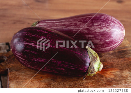 purple and white eggplant, on a wooden chopping board, top view, raw eggplant, no people, purple and white eggplant, on a wooden chopping board, top view, raw eggplant, no people, 122327588