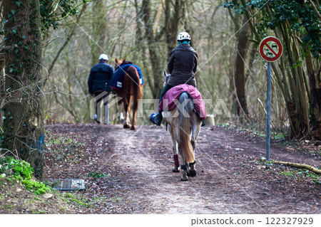 Couple of riders on a footpath in the forest Couple of riders on a footpath in the forest 122327929