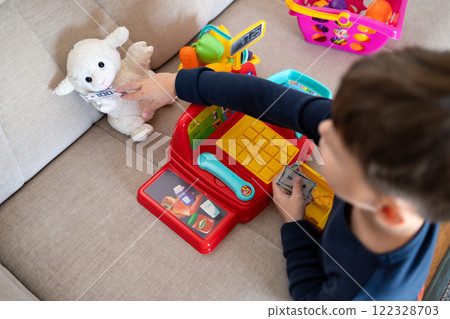 A child is playing store at home. 122328703