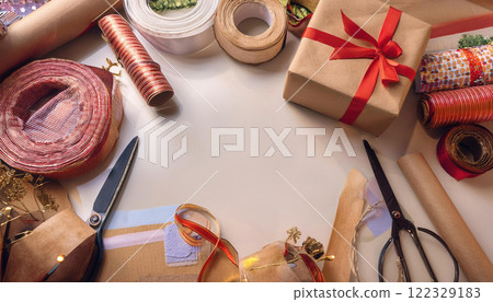 creative workspace filled with tools and materials for making handmade festive gifts, including ribbons, scissors, and wrapping paper, inspires joy and creativity 122329183