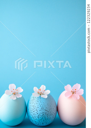 Easter blue background with three Easter eggs decorated with live flowers of spring trees. Banner with copy space, for text Easter blue background with three Easter eggs decorated with live flowers of spring trees. Banner with copy space, for text 122329234