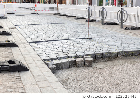 Construcion site of pavement granite cobblestone road in old city center installation or renovation repair. Roadworks stonework at pedestrian area. Paved sidewalk reconstruction. Urban development Construcion site of pavement granite cobblestone road in old city center installation or renovation repair. Roadworks stonework at pedestrian area. Paved sidewalk reconstruction. Urban development 122329445