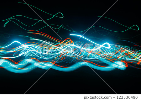 Abstract blurred colorful light effect on a black background. Long exposure photo of moving camera. Abstract blurred colorful light effect on a black background. Long exposure photo of moving camera. 122330480