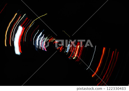 Abstract blurred colorful light effect on a black background. Long exposure photo of moving camera. Abstract blurred colorful light effect on a black background. Long exposure photo of moving camera. 122330483