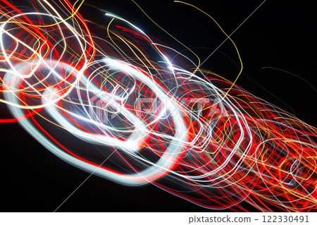 Abstract blurred colorful light effect on a black background. Long exposure photo of moving camera. Abstract blurred colorful light effect on a black background. Long exposure photo of moving camera. 122330491