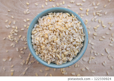 Flat Lay of Split Dehusked Black Gram (Matpe Beans) White Lentils in a Blue Bowl, Top View Flat Lay of Split Dehusked Black Gram (Matpe Beans) White Lentils in a Blue Bowl, Top View 122330924