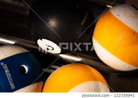 vibrant bowling ball in colorful, well-lit bowling alley with various balls and blurred background creating dynamic atmosphere vibrant bowling ball in colorful, well-lit bowling alley with various balls and blurred background creating dynamic atmosphere 122330941