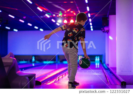 happy young boy child have fun cheering while playing bowling game bowling alley happy young boy child have fun cheering while playing bowling game bowling alley 122331027