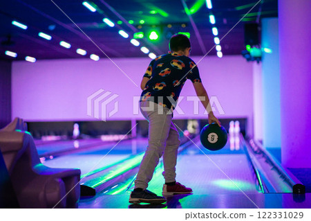 happy young boy child have fun cheering while playing bowling game bowling alley happy young boy child have fun cheering while playing bowling game bowling alley 122331029