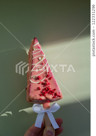 New look of trendy miniature ice cream cheesecake on stick in vibrant pink color on pastel background. Copy space mock up template sample for bakery mini dessert coffee shop. Cake to go takeaway sweet New look of trendy miniature ice cream cheesecake on stick in vibrant pink color on pastel background. Copy space mock up template sample for bakery mini dessert coffee shop. Cake to go takeaway sweet 122331296