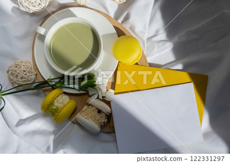 Empty white envelope letter mockup template Green latte match and macaron on messy bed. Concept of holiday breakfast morning tea drink. Cozy minimalist superfood vibrant colors healthy eating. Organic Empty white envelope letter mockup template Green latte match and macaron on messy bed. Concept of holiday breakfast morning tea drink. Cozy minimalist superfood vibrant colors healthy eating. Organic 122331297