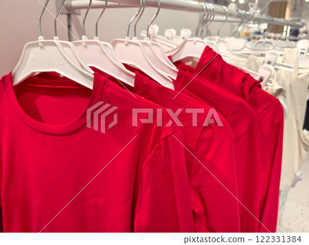 Colorful display of red shirts hanging in a store during daylight hours 122331384
