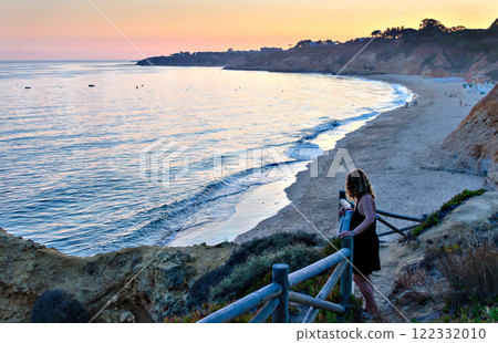 Woman watching the sunset on Santa Eulalia beach in Albufeira, Algarve region, Portugal 122332010