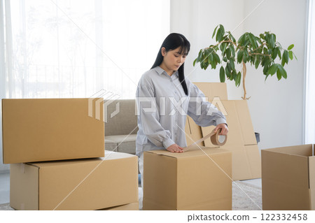 A woman putting duct tape on cardboard 122332458