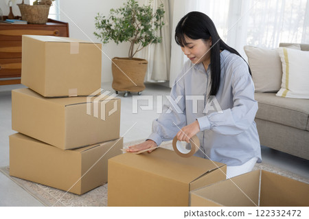 一名婦女將膠帶貼在紙板上 122332472