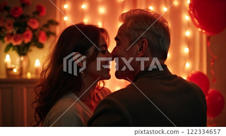 European mature couple in love hugging at home. The room is festively decorated with lights, flowers and heart-shaped balloons. Holiday, warm and cozy atmosphere. 122334657