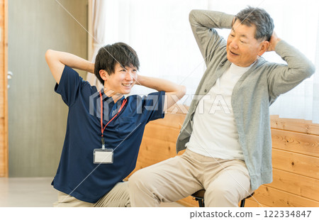 復健期間做體操的老人和男性物理治療師/職能治療師工作人員 復健期間做體操的老人和男性物理治療師/職能治療師工作人員 122334847