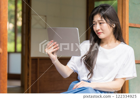 A young woman is moved by watching a video on a tablet A young woman is moved by watching a video on a tablet 122334925