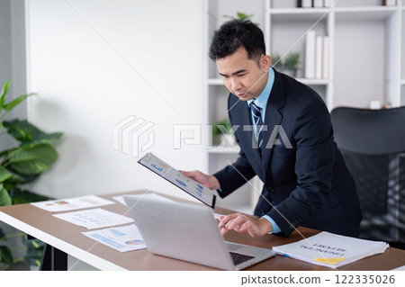 Business professional engaging in data analysis modern office digital workspace focused environment strategic insights 122335026