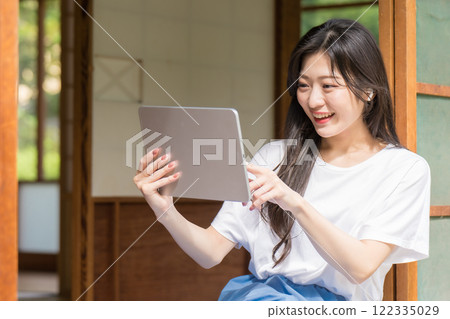年輕女子看著平板電腦並使用觸控控制 122335029