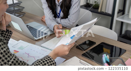 Business team analyzing data charts and discussing strategies in a modern office Business team analyzing data charts and discussing strategies in a modern office 122335110